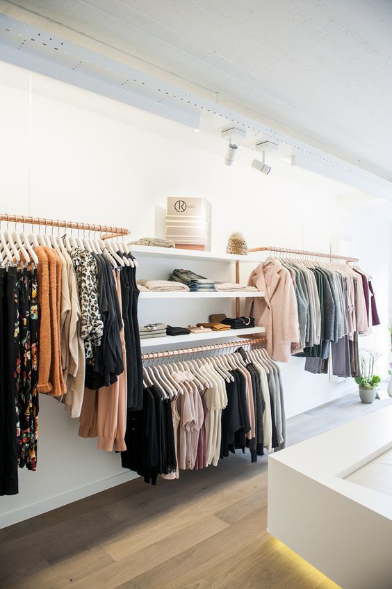 a minimalist closet done of copper holders for hangers and some open shelving is a cool idea to try