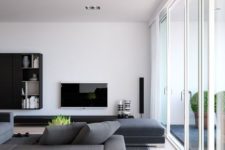a minimalist living room with grey furniture, a TV, a wall-mounted storage unit and a glazed wall for much natural light