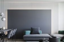 a minimalist living space with a chalkboard wall, dark coffee tables, a grey sectional sofa plus colored pillows