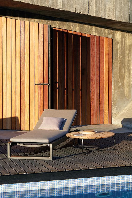 a minimalist lounger with dark metal framing and taupe upholstery with pillows is a nice fit for a modern or minimalist space