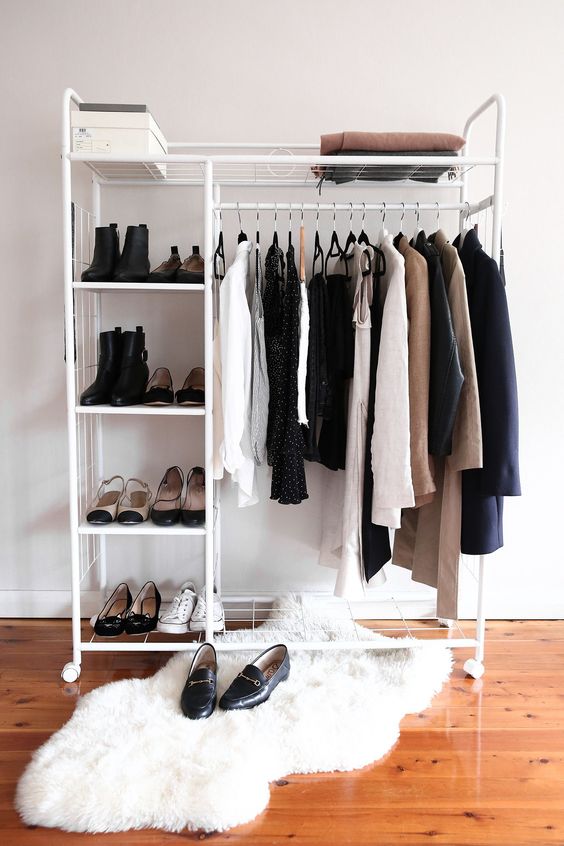 a minimalist makeshift closet with shoe shelves, a box and some space for clothes hangers