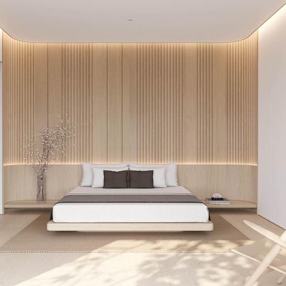 A neutral minimalist bedroom with a light stained slab wall, a floating bed and nightstands, built in lights is cool