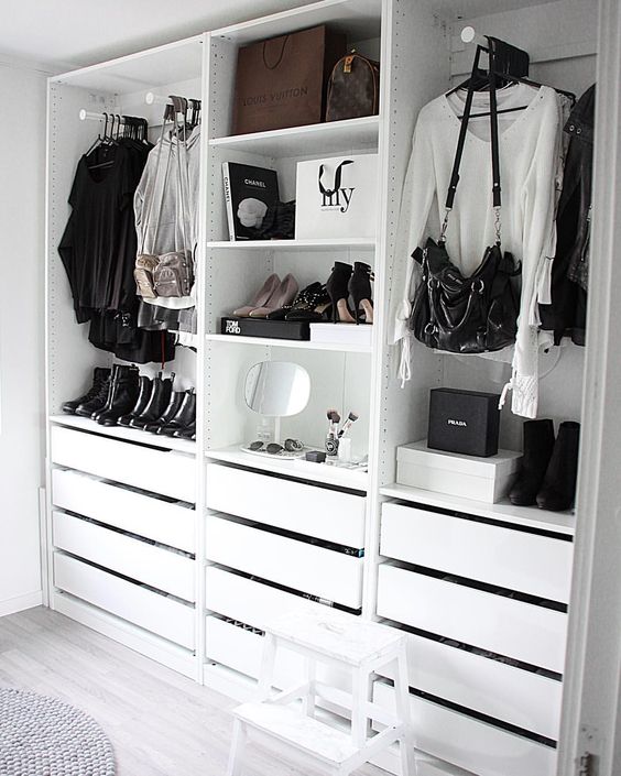 a simple and minimalist closet with holders for clothes and bags, with drawers and open shelves for various stuff
