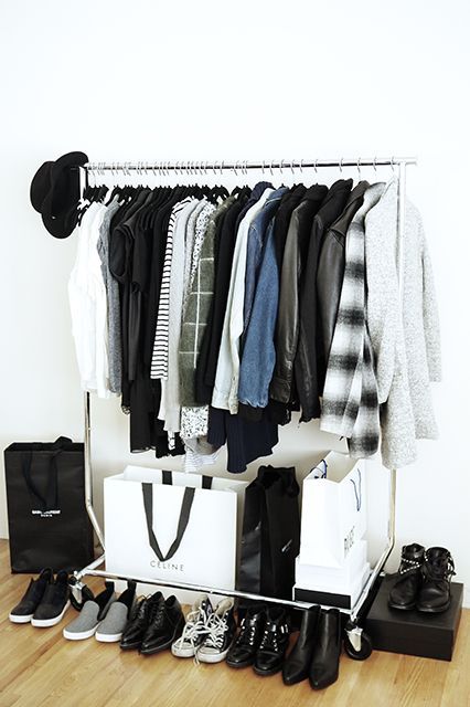 a stylish makeshift closet with shoes stored around and some bags used for storage, too
