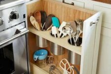 a vertical drawer with utensil holders and storage next to the cooker is a cool idea for a kitchen, and while cooking you will have everything at hand