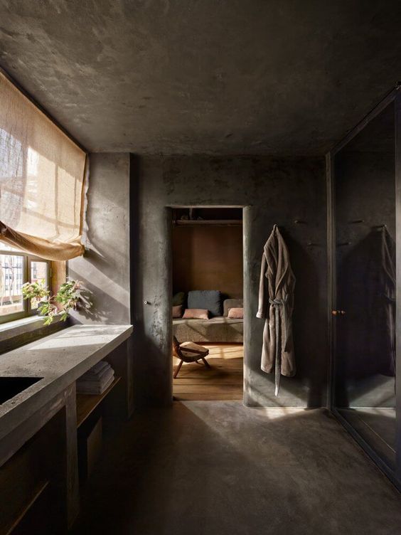 A wabi sabi kitchen fully done in concrete, with a countertop and a curtain for a softer touch