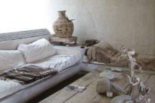 a wabi-sabi living room with brutal wooden furniture, vases, stones and concrete walls