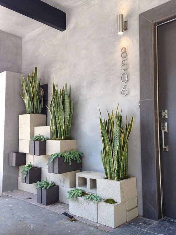 stylish stacked concrete planters in grey and black with various kinds of plants will totally change your outdoor space