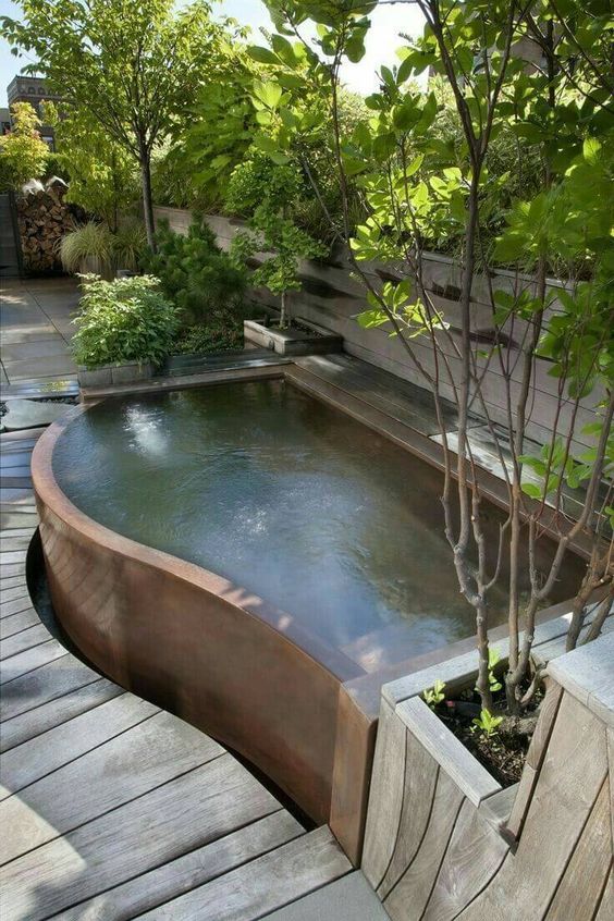 a curved plunge pool with potted and planted greenery around will refresh you very well on a hot day