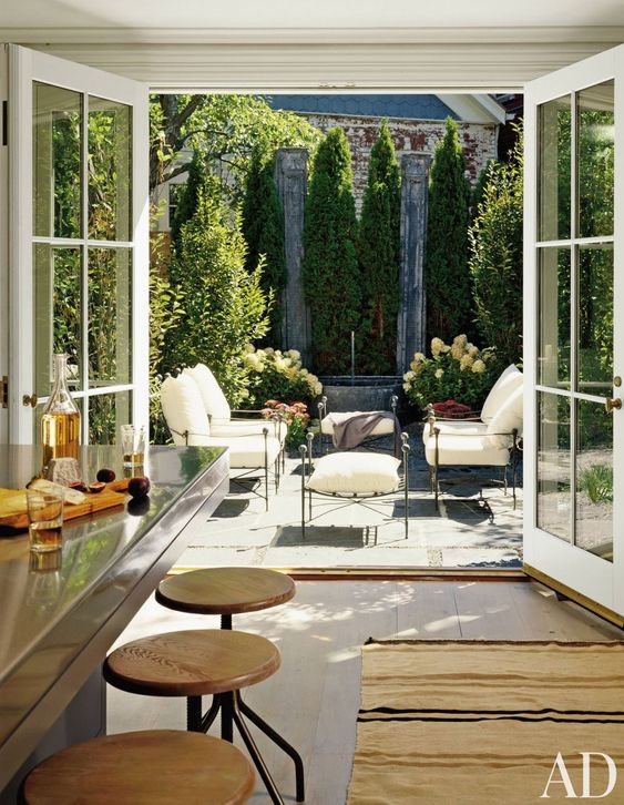a kitchen with French doors that can be opened to a very elegant terrace outdoors and make it part of the interior