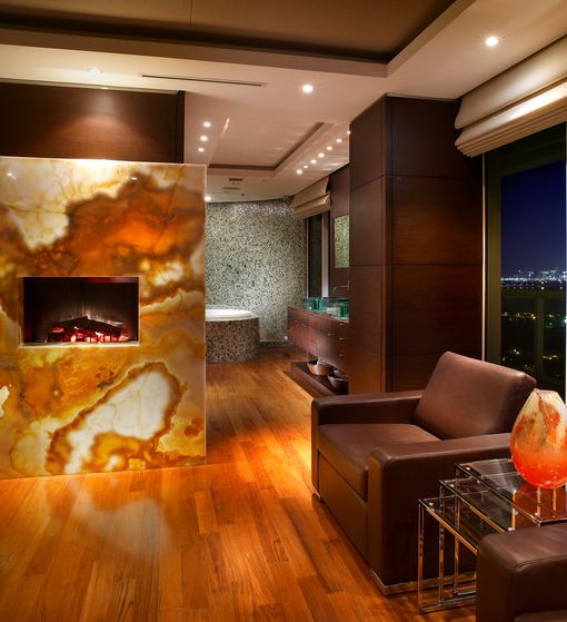 a lit up onyx slab statement wall with a fireplace is pure luxury that takes your breath away