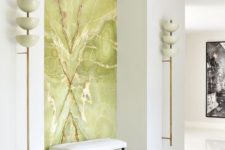 a luxurious white entryway accented with a green onyx statement wall looks really breahttaking
