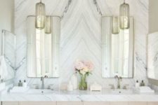 a luxurious white marble accent wall completes the neutral and veyr chic look of this bathroom