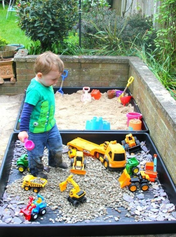 a mini sand box and a mini toy playground with colorful toy cars for a little boy to spend time outdoors