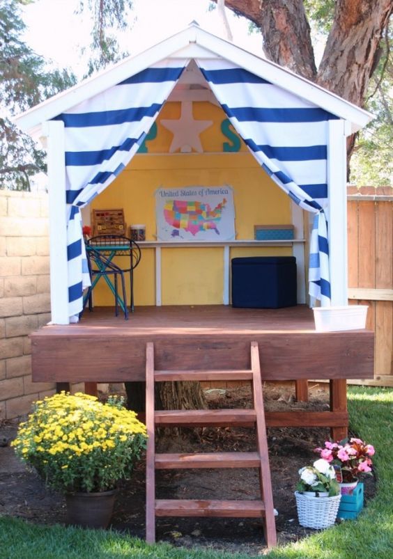a small backyard house with a creativity space and lots of blooms around will be loved by your kids