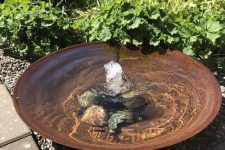 a super simple modern bowl fountain with rocks on the bottom is a great water feature for a modern garden, and your pets can refresh themselves in it