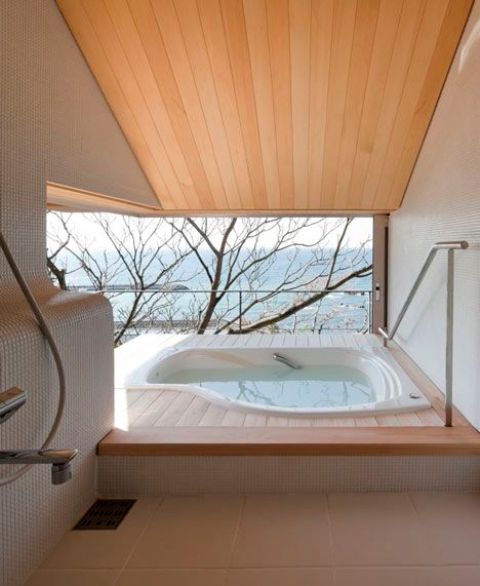 an outdoor-indoor minimalist bathroom with an asymmetrical bathtub, a view and a terrace to enjoy the views as much as possible