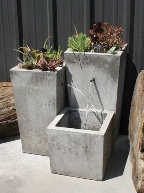 An ultra modern or minimalist fountain composed of tall concrete planters is a stylish solution for a modern space