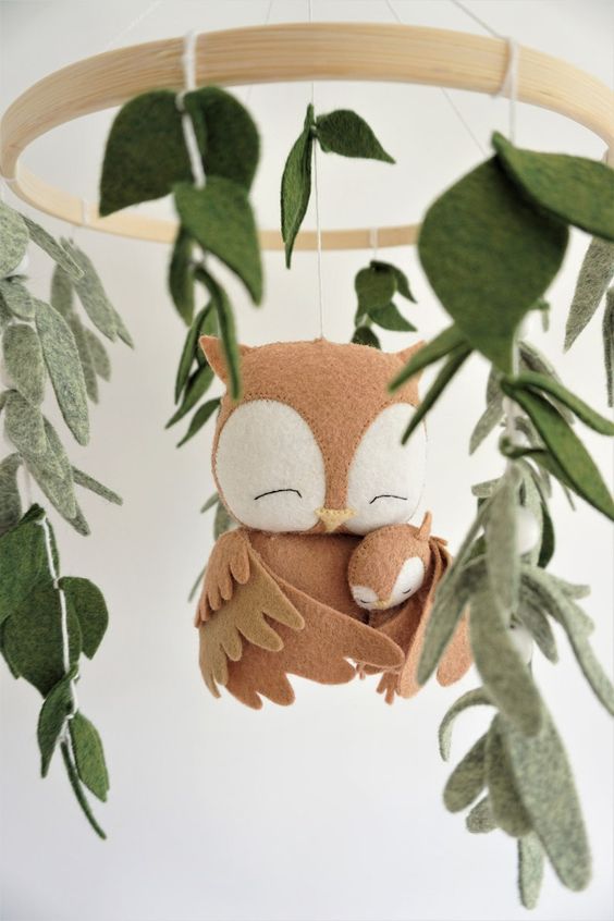 a baby mobile with a couple of owls and leaves is a cozy idea for a forest or just neutral and relaxed nursery
