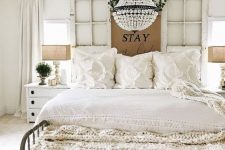 a beautiful shabby chic bedroom with window frames, refined furniture, a crystal chandelier and ruffle bedding