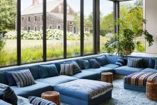 a blue conversation pit with a large sofa that takes three sides, lots of pillows, some woven coffee tables is wow