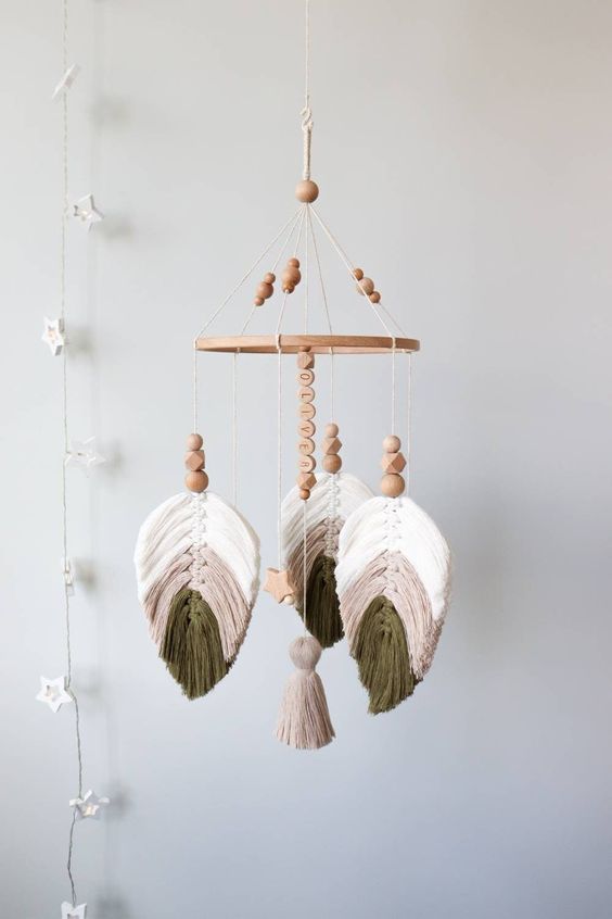 a boho neutral macrame mobile with monstera leaves, wooden beads, a tassel and a wooden bead name is a super cute and cool idea for a neutral nursery