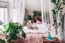 a boho sleeping space is separated from the rest of the space with mosquito net curtains