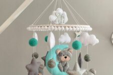 a fun and colored baby mobile with clouds, stars, a car and some teddy bears done in white, grey and turquoise