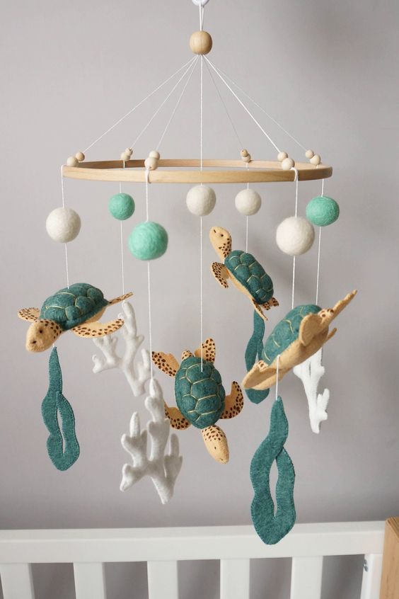 a gorgeous turtle mobile with turtles, corals, sea weed and pompoms done of green and white felt is a cool idea for a beach nursery