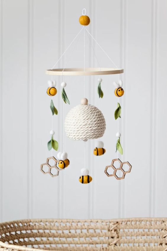 a honey-themed nursery mobile with a hive, bees, honey combs, felt and wooden beads and is a cool idea for a honey-themed nursery