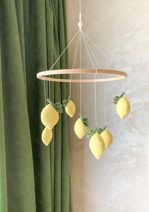 a lovely and bold yellow felt lemon mobile with leaves is a cool and chic idea for a botanical-themed space or a Mediterranean one