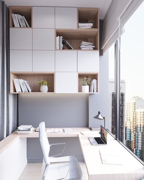 a minimalist home office with a gorgeous view, a shelving unit, a large corner desk and a table lamp is a chic and inspiring space