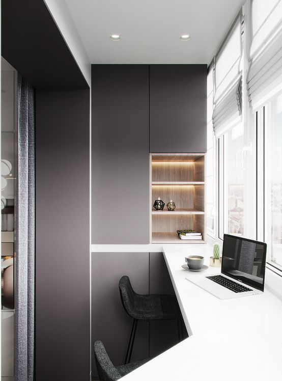 A minimalist home office with built in storage units and shelves, a tall shared desk and a view is a very chic nook to work or have meals