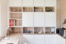 a minimalist home office with white and stained storage units, with a built-in desk and some pretty decor is very chic