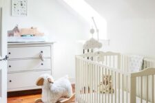 a neutral attic nursery with simple and casual furniture, muted and printed textiles plus lots of cute toys