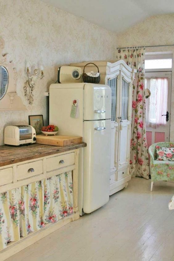 a neutral shabby chic space with refined vintage furniture, floral curtains instead of doors, floral textiles and a wall sconce