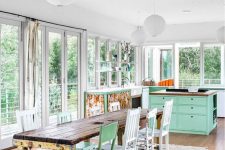 a pastel-infused shabby chic kitchen with aqua furniture, a shabby table, mismatching chairs and floral prints