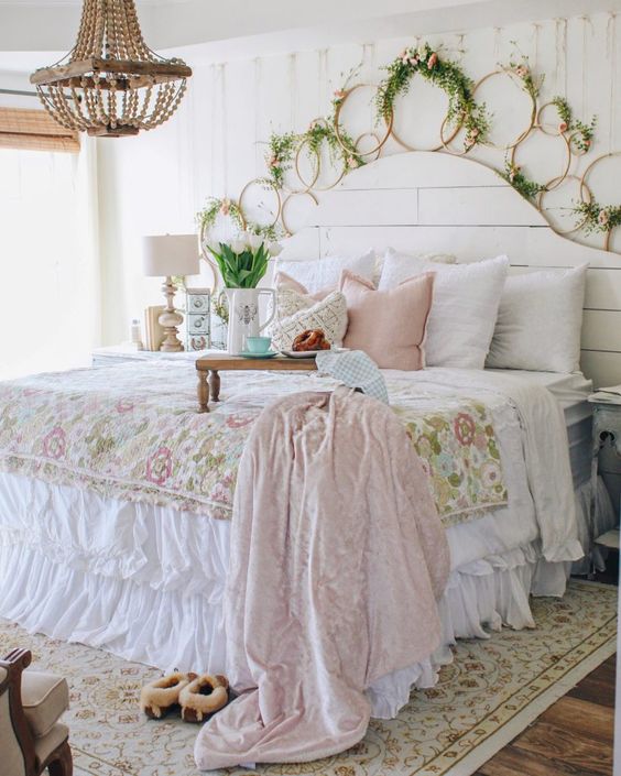 a pastel shabby chic bedroom with a white beadboard bed, pastel and floral bedding, lots of hoops with blooms, a bead chandelier