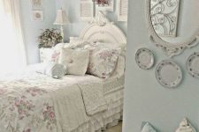 a pastel shabby chic bedroom with blue walls, shutters, plates, a mirror, floral bedding and a gallery wall