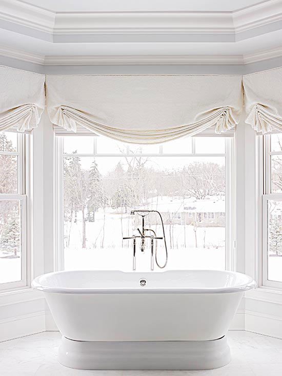 a refined bathroom with a view with neutral Roman shades that makes the space private whenever it's needed