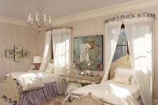 a refined shabby chic shared kids’ bedroom with wallpaper walls, a lavender ceiling, elegant vintage furniture, canopies and a pretty chandelier