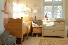 a rustic shabby chic kids’ bedroom with vintage furniture, a crystal chandelier, a floral rug and baskets plus decorative plates