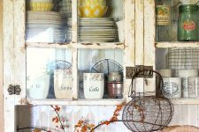 a rustic shabby chic kitchen in neutrals, with glass cabinets, beadboard walls, vintage pottery and porcelain for beautiful decor