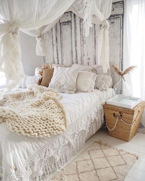 a shabby boho bedroom with shabby doors instead of a headboard, a canopy, crochet and lace pillows, a basket nightstand