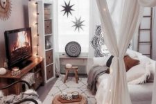 a small boho living room accented with mosquito net curtains and lights interwoven
