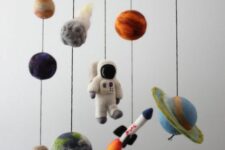 a space-themed nursery mobile with planets, a rocket and a spaceman of felt is a super cool and fun idea for a space-themed room