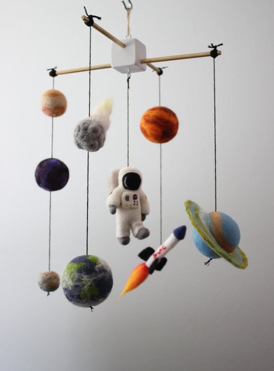 a space-themed nursery mobile with planets, a rocket and a spaceman of felt is a super cool and fun idea for a space-themed room