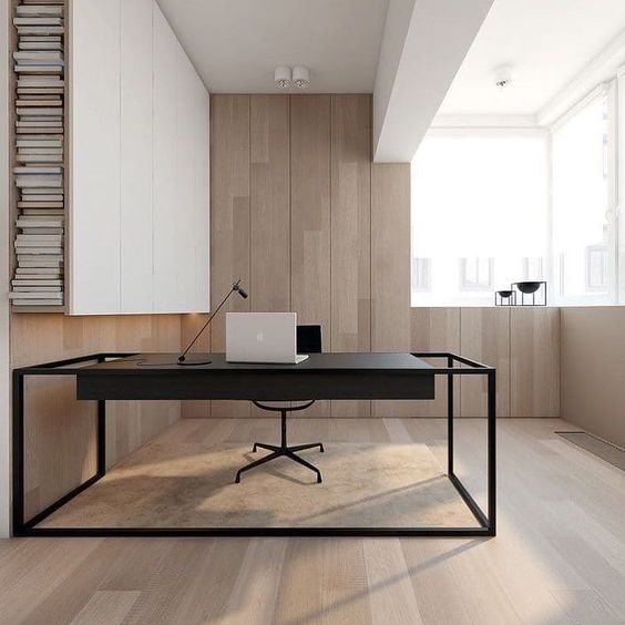 a stylish minimalist home office clad with light stained wood, with a large sleek white storage unit, a black desk and a glazed wall
