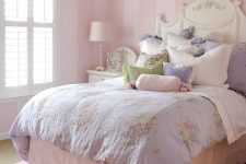 a vintge to shabby chic kid’s bedroom with pink striped walls, a refined white bed, pastel floral bedding, a purple curtain and a crystal chandelier