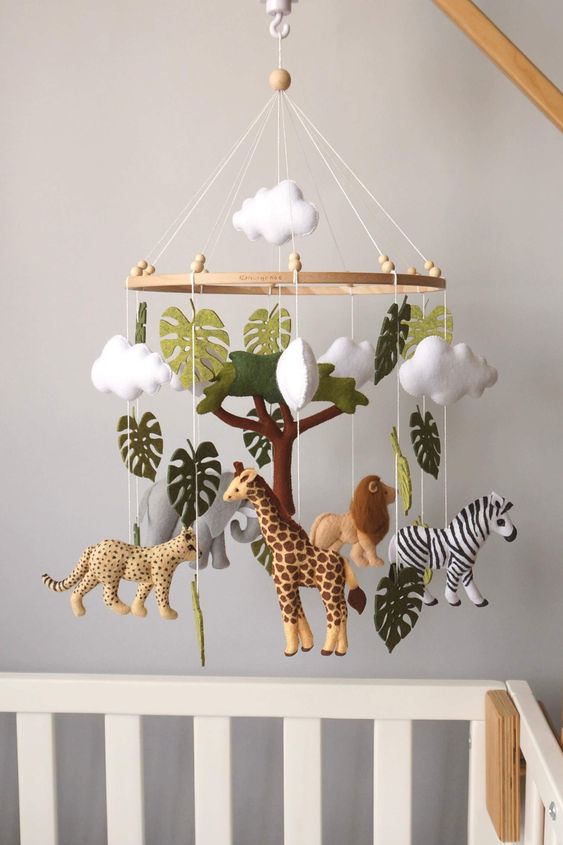 an African-themed nursery with savanna naimals, monstera leaves and clouds is a super cool and bold idea for the space